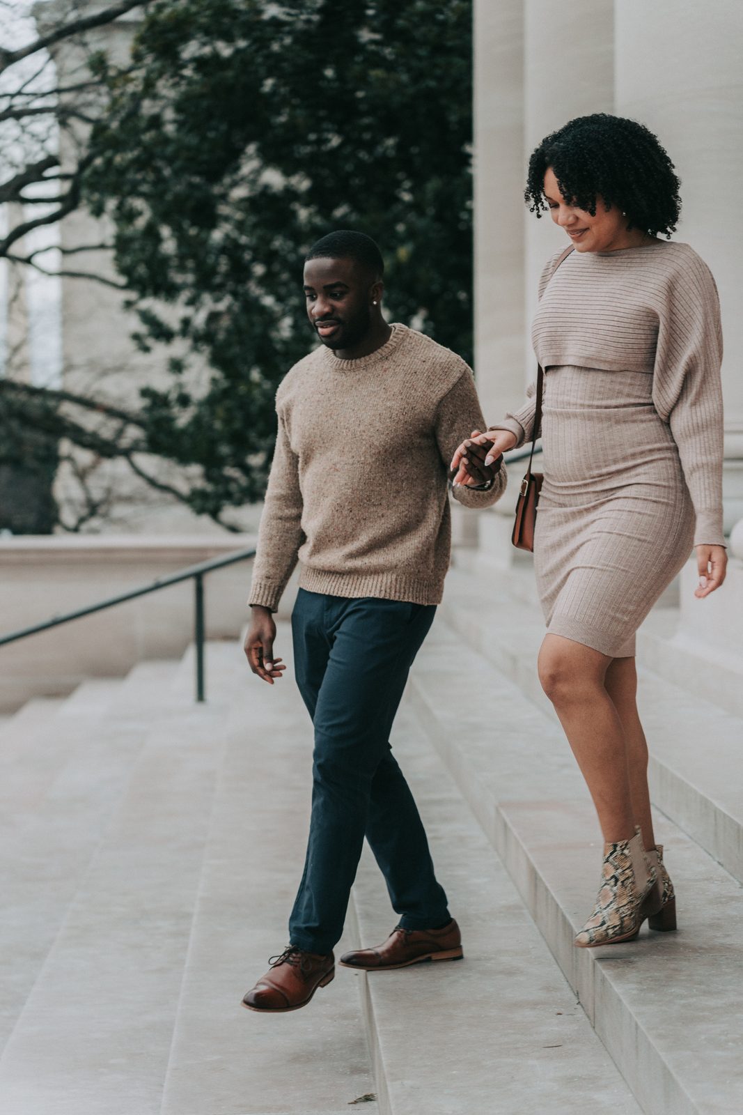 Couple holding hands as they walk down wide stone steps